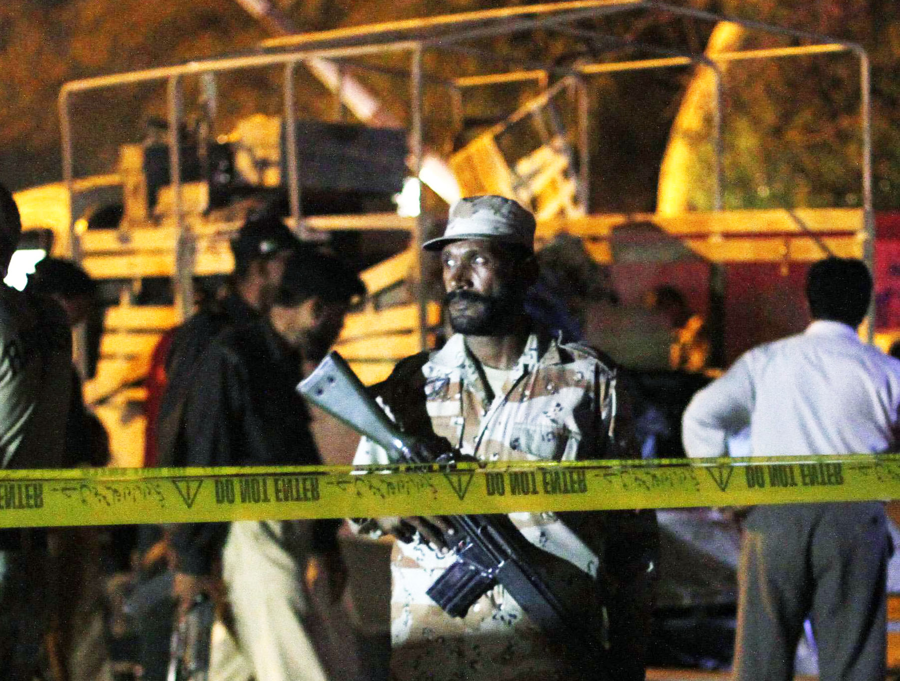 a ranger stands guard at the site of a bomb explosion targetting a paramilitary truck background in karachi on april 3 2013 photo reuters