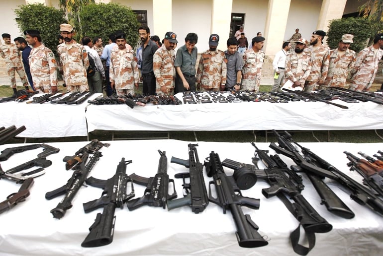 pakistani rangers and journalists stand beside a display of confiscated weapons during a media briefing photo reuters file