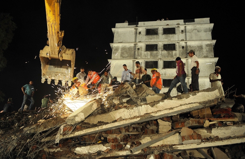 indian rescue workers cut metal rods as they look for survivors in the debris of a collapse building in mumbra on the outskirts of mumbai on april 4 2013 photo afp