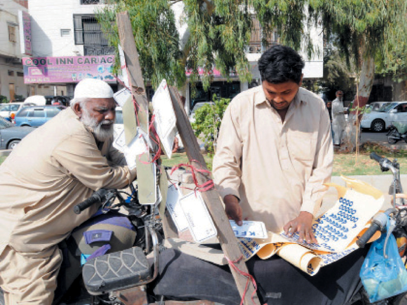 a person selling white license plates with the registration numbers in blue colour at shahrah e quaideen police has given 15 days to all motorcycle owners to change their fancy plates to standardised ones photo rashid ajmeri express