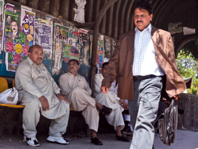 a man walks past a bus stop plastered with political posters for a candidate for islamabad s na 49 constituency photo myra iqbal express a man walks past a bus stop plastered with political posters for a candidate for islamabad s na 49 constituency photo myra iqbal express