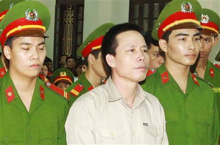 doan van vuon c stands with policemen in front of the dock at a court during a verdict session in hai phong photo reuters