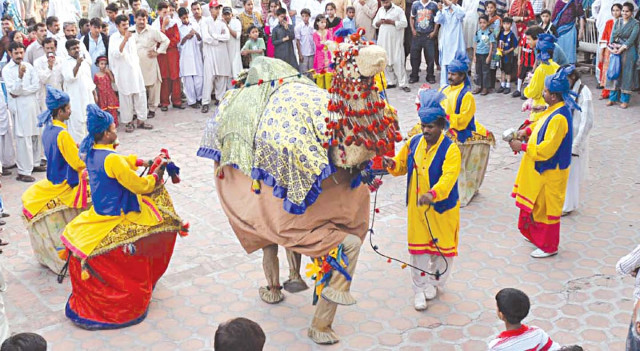 people in a camel suit along with other performers dance at the concluding day of lok mela photo express