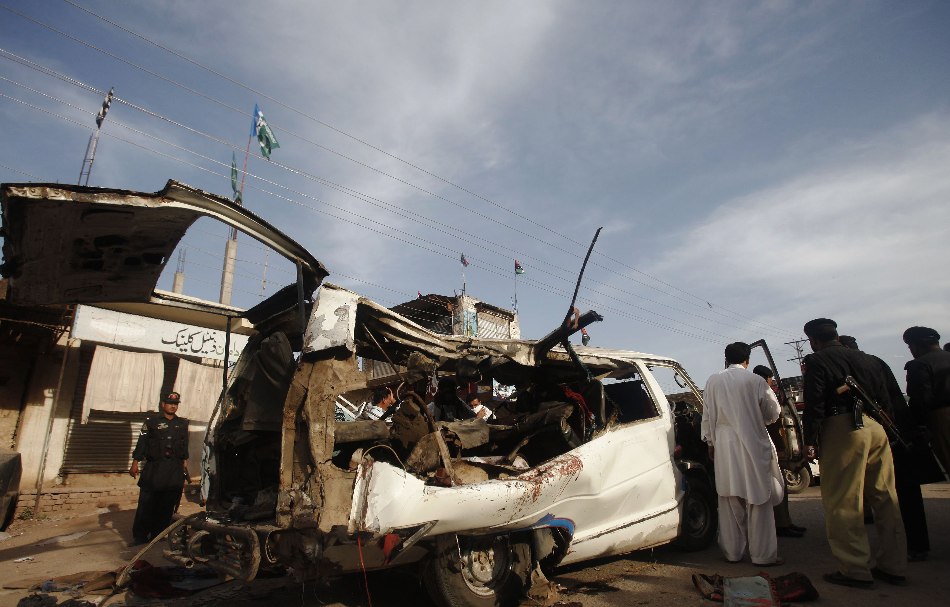 police officials inspect a damaged van at the site of a bomb blast in the mattani bazaar on the outskirts of peshawar april 13 2013 photo reuters