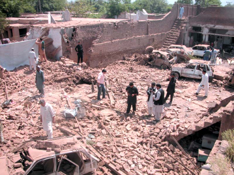 people gather at the remains of the badabher police station which was completely destroyed when a huge cache of explosives stored in the building went off due to a short circuit photo iqbal mamond express