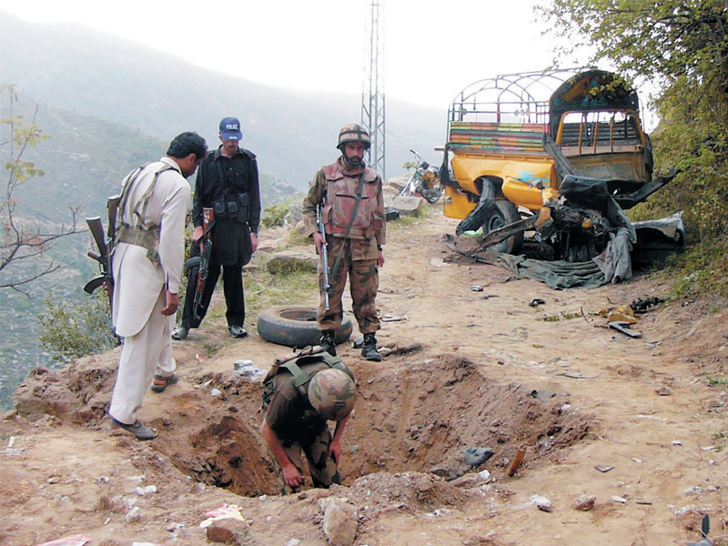 soldiers examine the site of a bomb explosion on the outskirts of mingora photo afp