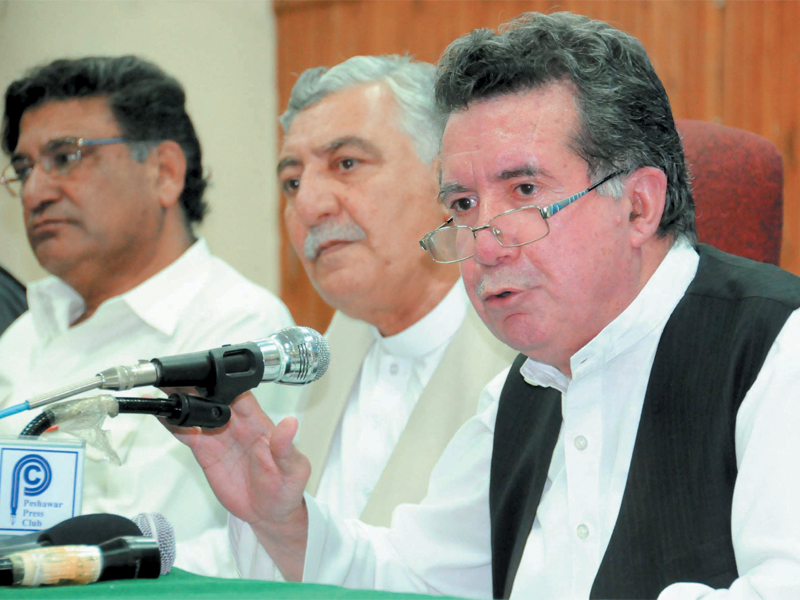 senator afrasiab khattak right anp provincial leader tajuddin khan centre and former sports minister aqil shah left address journalists at the peshawar press club photo muhammad iqbal express