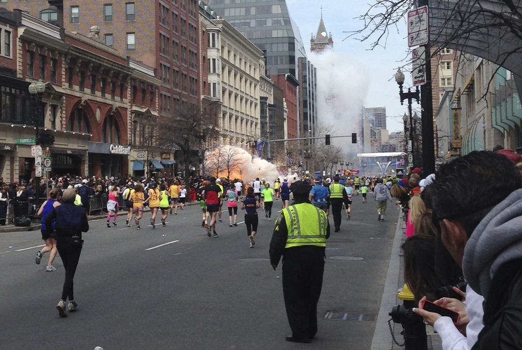 runners continue to run towards the finish line of the boston marathon as an explosion erupts near the finish line of the race in this photo photo reuters