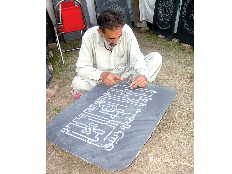 a stone carver displaying his work at the festival photo express