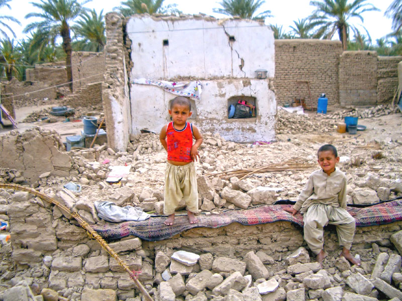 children sit on the rubble of their house that collapsed in the quake in the town of mashkhel balochistan photo reuters