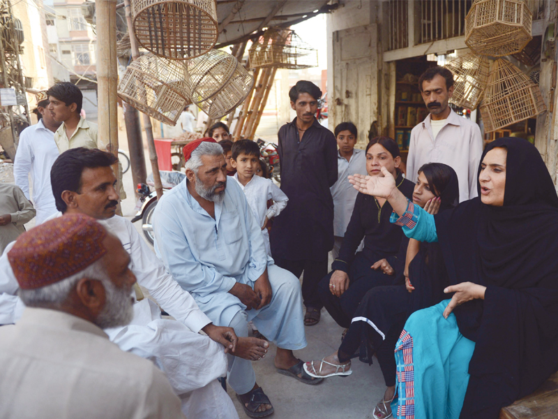 sanam faqeer right an independent candidate for the forthcoming general elections speaks to traders while campaigning in sukkur on april 5 photo afp