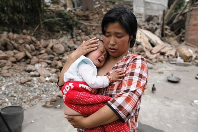 survivor chen zhirong comforts her 18 month old son next to debris at a village on the second day after an earthquake hit longmen township of lushan county sichuan province april 21 2013 photo reuters survivor chen zhirong comforts her 18 month old son next to debris at a village on the second day after an earthquake hit longmen township of lushan county sichuan province april 21 2013 photo reuters