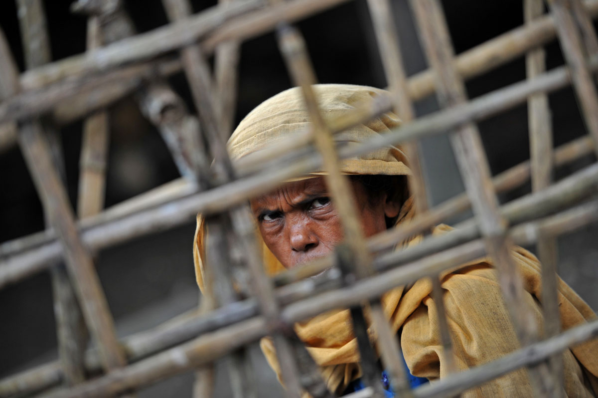 a muslim rohingya woman sits outside her temperary shelter at a village in minpyar in rakhine state on october 28 2012 photo afp