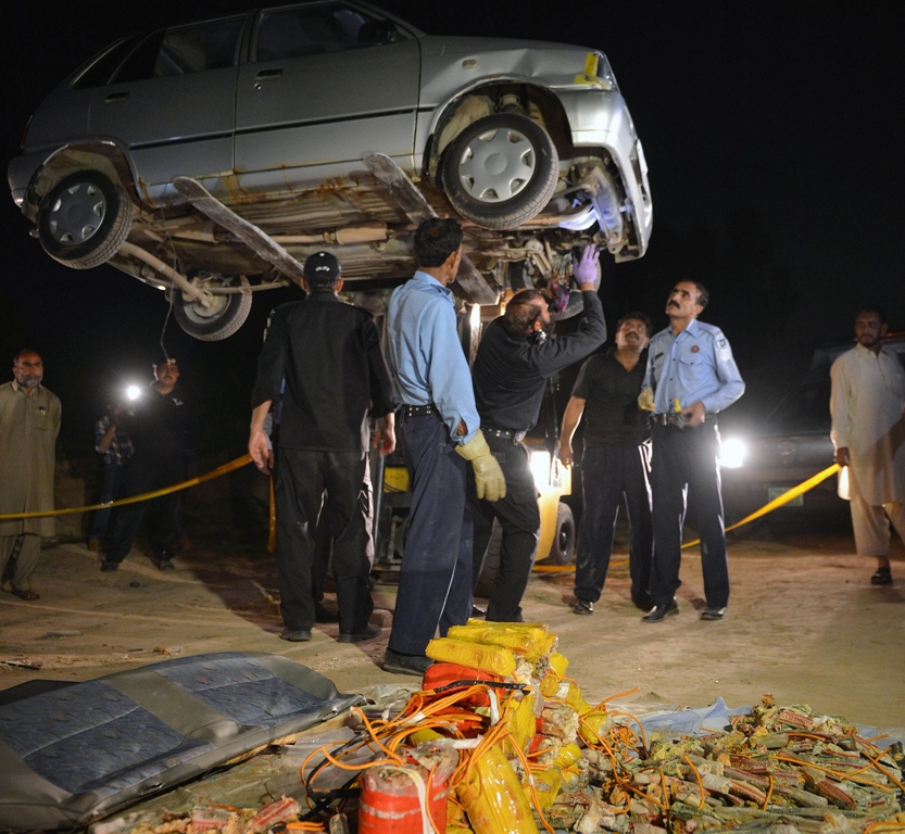 security officials search a vehicle found packed with explosives after its seizure by police in the outskirts of islamabad on april 23 2013 photo afp