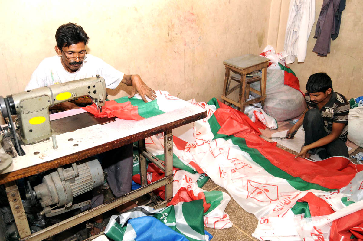 workers prepare posters of the political party muttahida qaumi movement in karachi for the upcoming general elections photo mohammad noman express