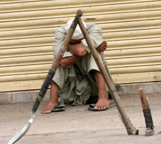 a labourer sits beside closed shops in karachi during a strike on wednesday photo athar khan express a labourer sits beside closed shops in karachi during a strike on wednesday photo athar khan express