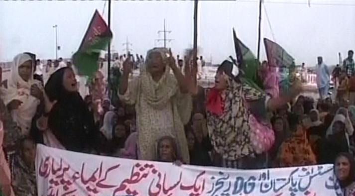 a screengrab shows women holding banners and protesting against the death of the three lyari residents screengrab express news