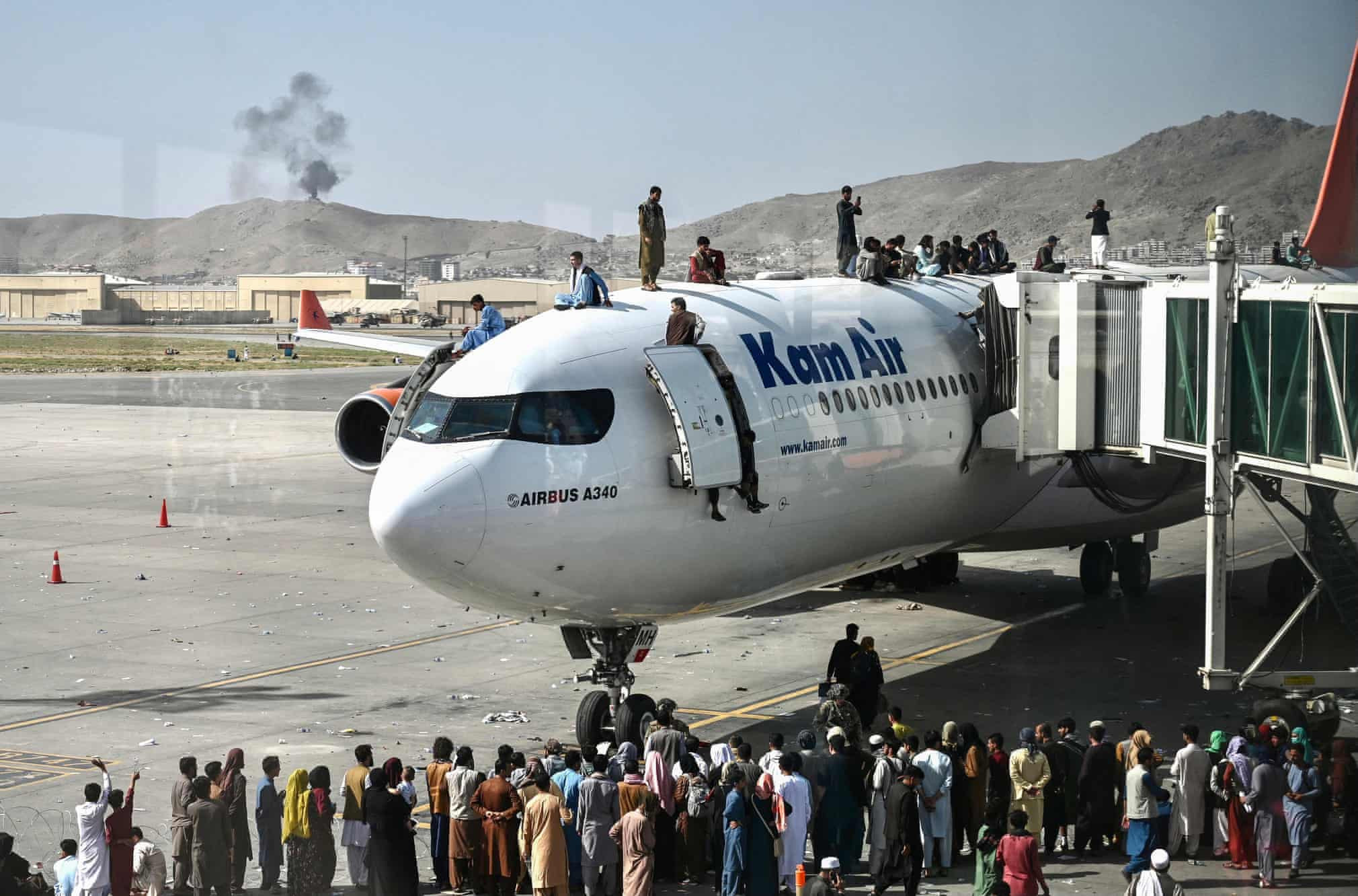 Afghans climb atop a plane at the Hamid Karzai International Airport in Kabul. Photo: AFP