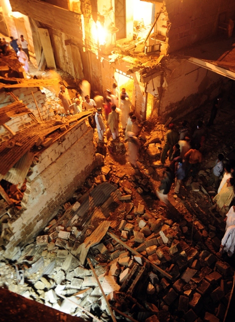 security officials and local residents gather at the site of the bomb explosions photo afp