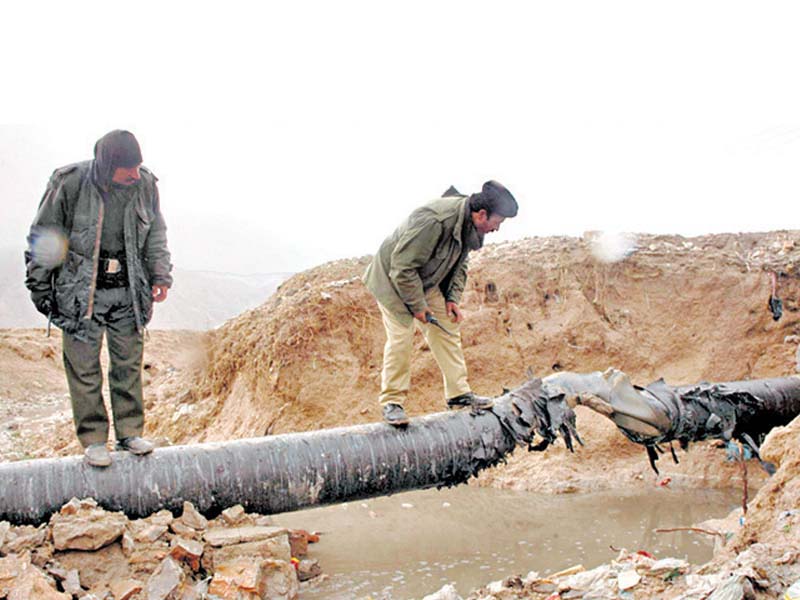 this file photo shows two security officials inspecting a section of a gas pipeline blown up by militants in balochistan