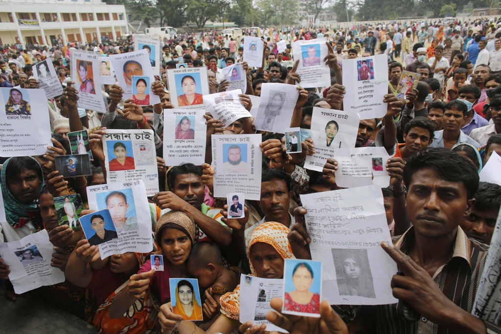 relatives mourn as they show pictures of garment workers who are believed to be trapped under the rubble of the collapsed rana plaza building in savar 30 km 19 miles outside dhaka april 28 2013 photo reuters