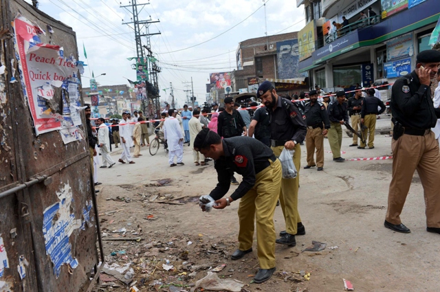 pakistani policemen inspect the site of a bomb blast in peshawar photo afp