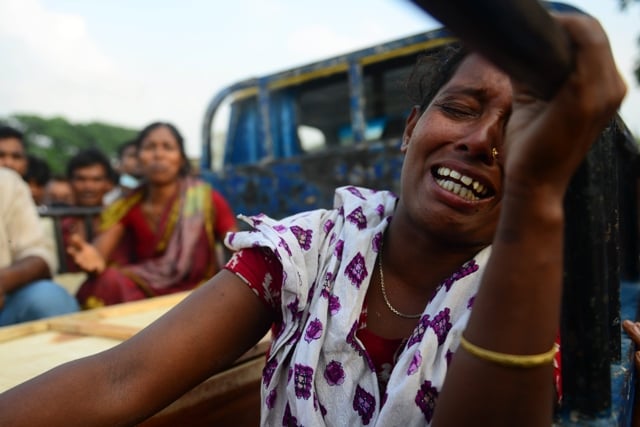 bangladeshi relatives react next to the coffin of a victim after an eight storey building collapsed in savar on the outskirts of dhaka on april 28 2013 a fire broke out in the wreckage of a bangladesh factory complex at night on april 28 killing the last known survivor from the building 039 s collapse five days earlier the national fire chief said photo afp mnuir uz zaman