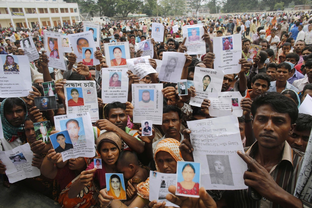 relatives mourn as they show pictures of garment workers trapped under the rubble of the collapsed rana plaza building in savar 30 km 19 miles outside dhaka april 28 2013 photo reuters