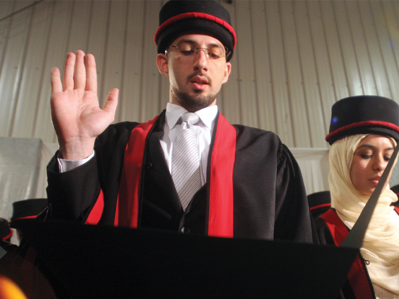 a graduate raises his hand in a symbolic gesture as he takes the hippocratic oath during the 10th convocation ceremony of ziauddin university on tuesday photo athar khan express