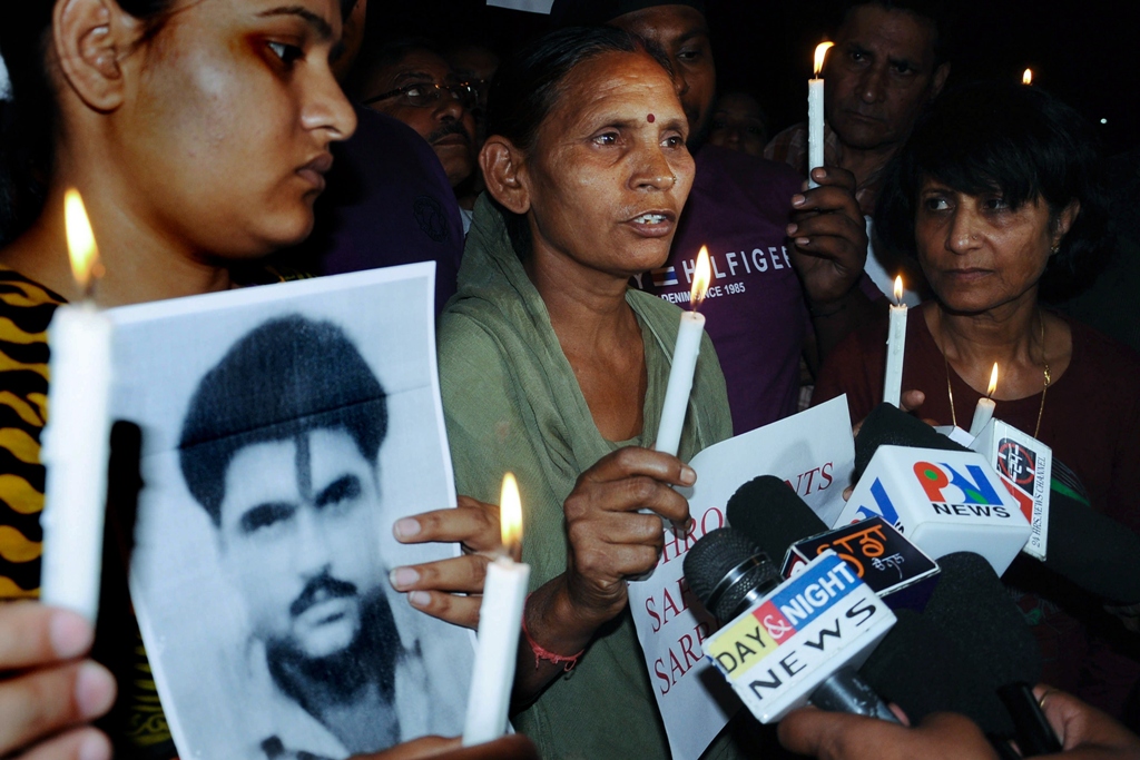 sukhpreet kaur c wife of indian death row prisoner in pakistan sarabjit singh and singh 039 s daughter swapandip l along with members of the akhil bhartiya human rights organisation abhro hold a candlelight vigil for the good health of sarabjit singh in amritsar on april 27 2013 photo afp file