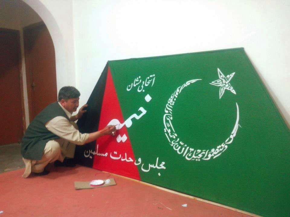 a worker paints an election banner of majlis e wahdat ul muslimeen mwm photo publicity