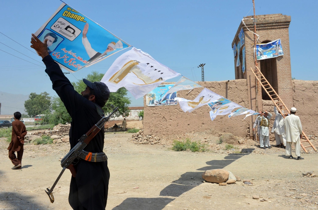 in this photograph taken on may 2 2013 shows supporters of a pakistani independent candidate for national assembly shah g gul afridi hang electoral posters during an election campaign in jamrud is in khyber district photo afp