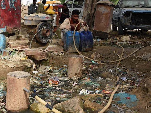 a man fills a container with water in a slum area of karachi photo afp