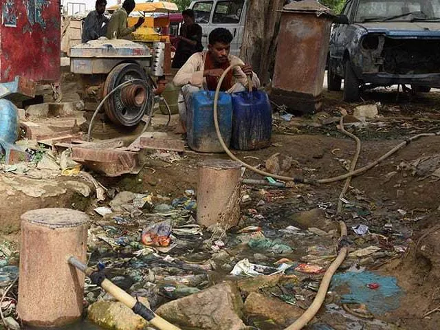 a man fills a container with water in a slum area of karachi photo afp a man fills a container with water in a slum area of karachi photo afp