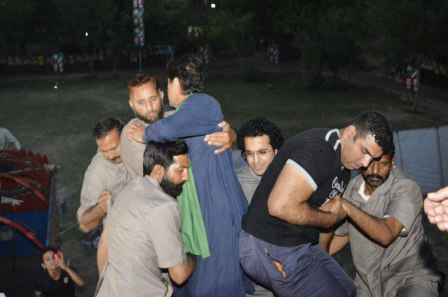 imran khan in blue falls as guards and supporters try to climb aboard the lift he is standing on photo pti social media imran khan in blue falls as guards and supporters try to climb aboard the lift he is standing on photo pti social media