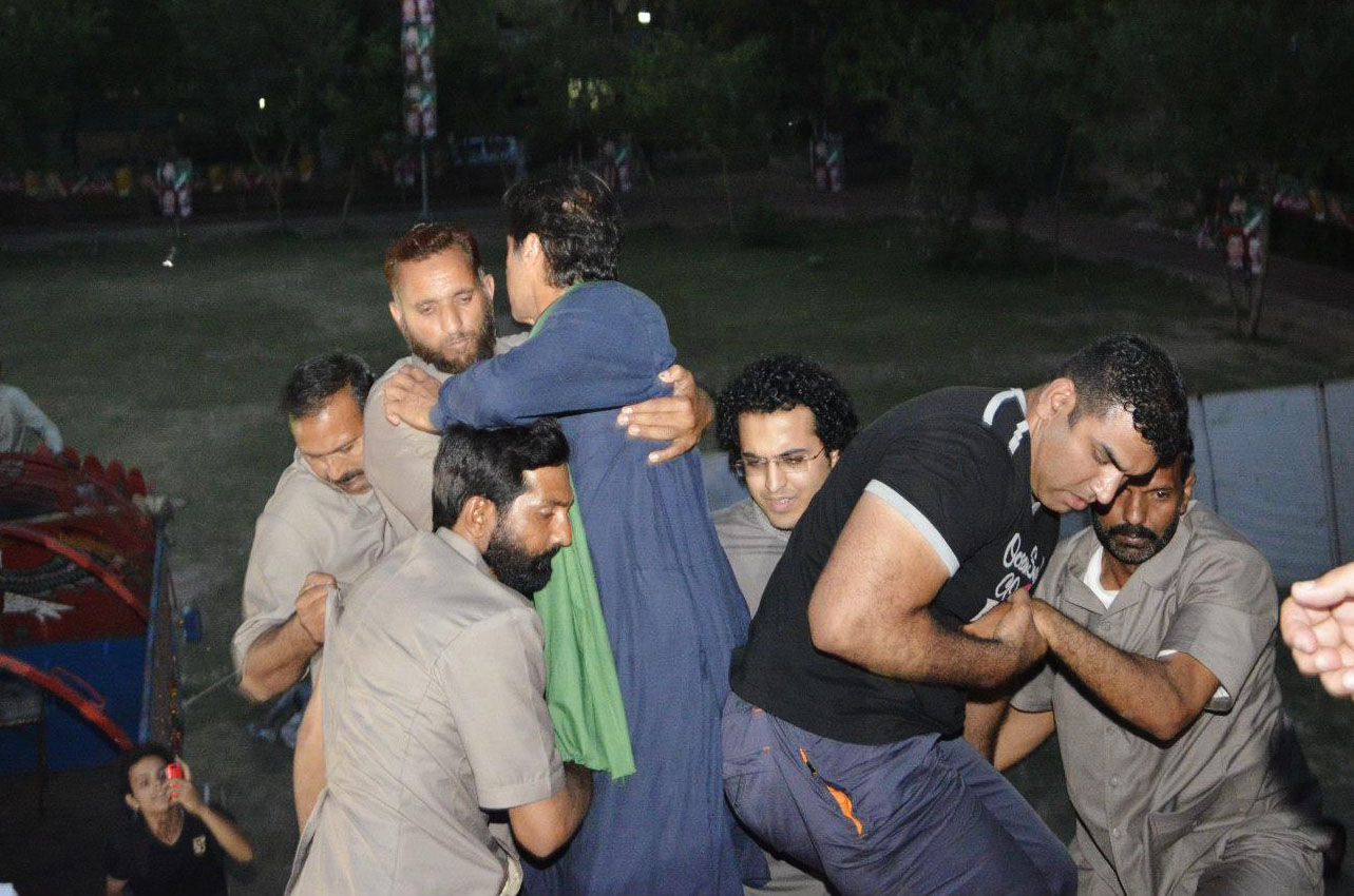 imran khan in blue falls as guards and supporters try to climb aboard the lift he is standing on photo pti social media