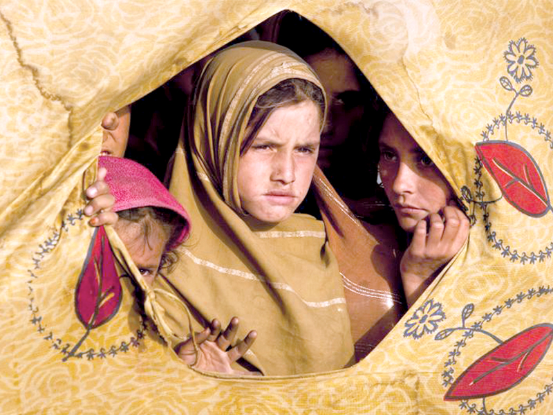 a group of young girls gaze out of a tent in jalozai camp peshawar photo file