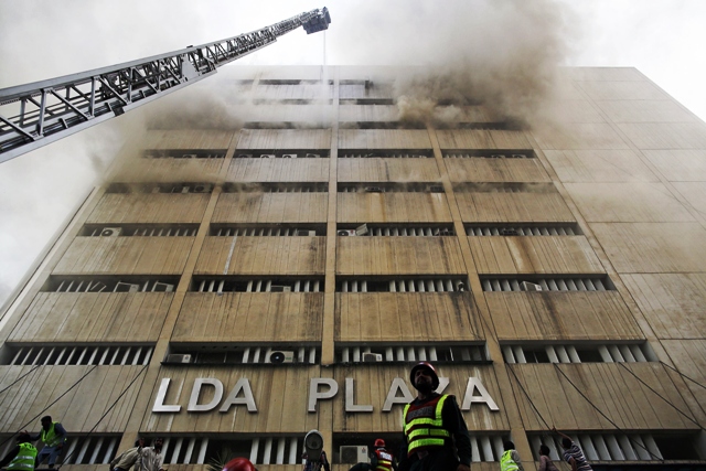rescue workers try to save people trapped inside a burning building in central lahore may 9 2013 photo reuters