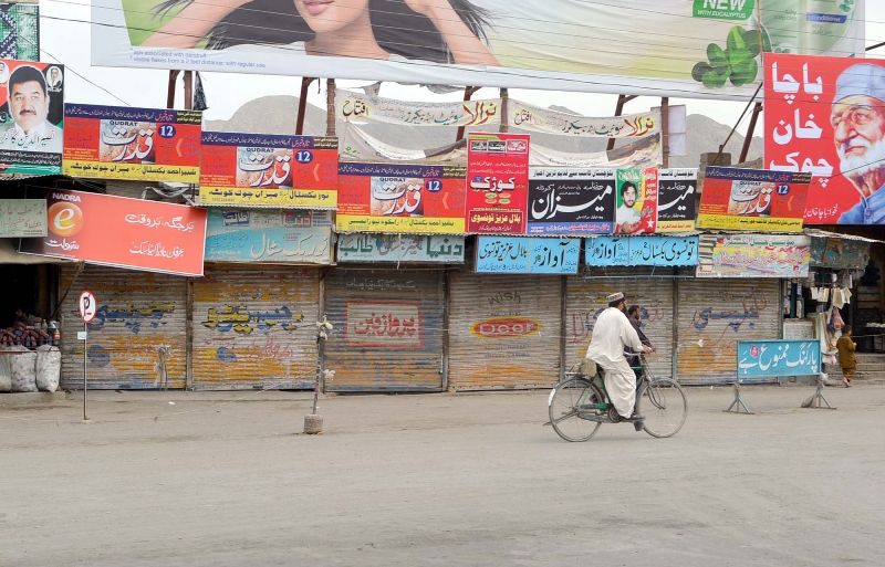 protest against polls a lone cyclist pedals past shops closed due to strike in quetta on thursday photo express