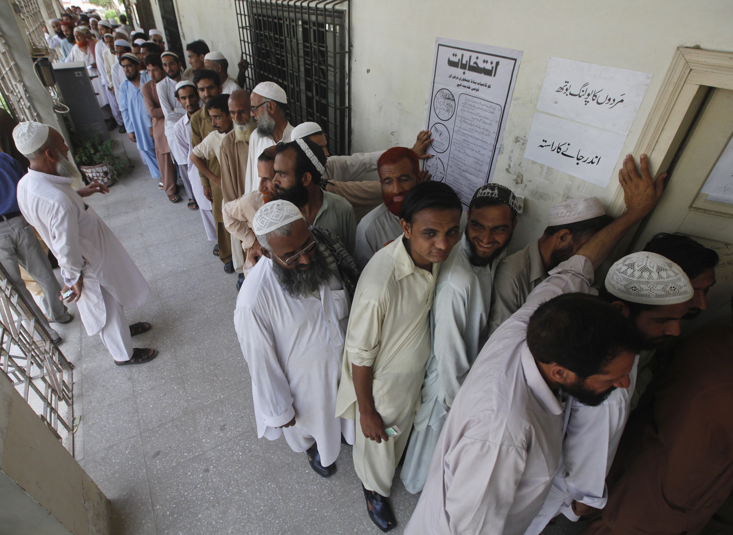 voters line up as they wait for their turn to cast their vote at a polling station in karachi photo retuers