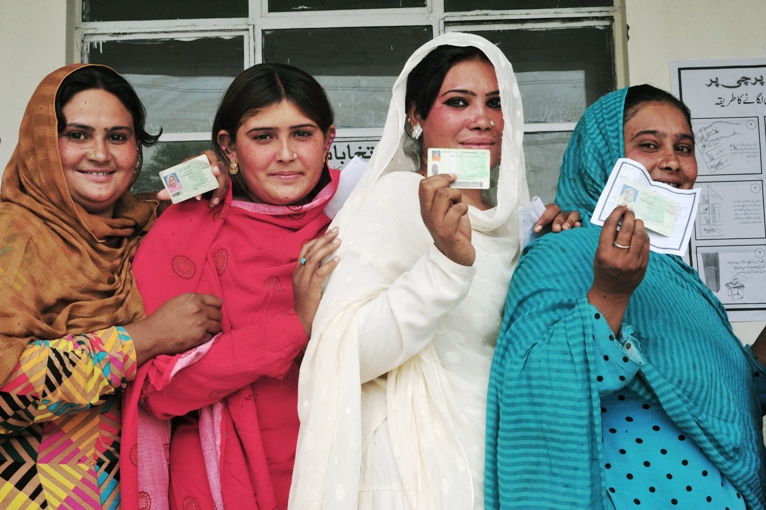 pakistani voters pose with their national identity cards as they queue to cast their ballots at a polling station during the general election in rawalpindi on may 11 2013 photo afp