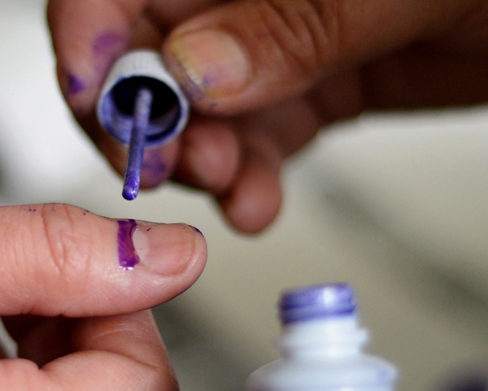 election presiding officer marks a voter at a polling station during the general election in rawalpindi on may 11 2013 photo afp