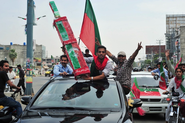 activists of pakistan tehreek e insaf pti wave flags as they drive through the streets during the general election on may 11 2013 photo afp