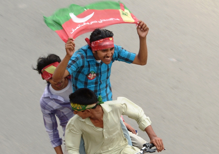 activists of pakistan tehreek e insaf pti wave party flags as they drive through the streets during the general election in rawalpindi on may 11 2013 photo afp