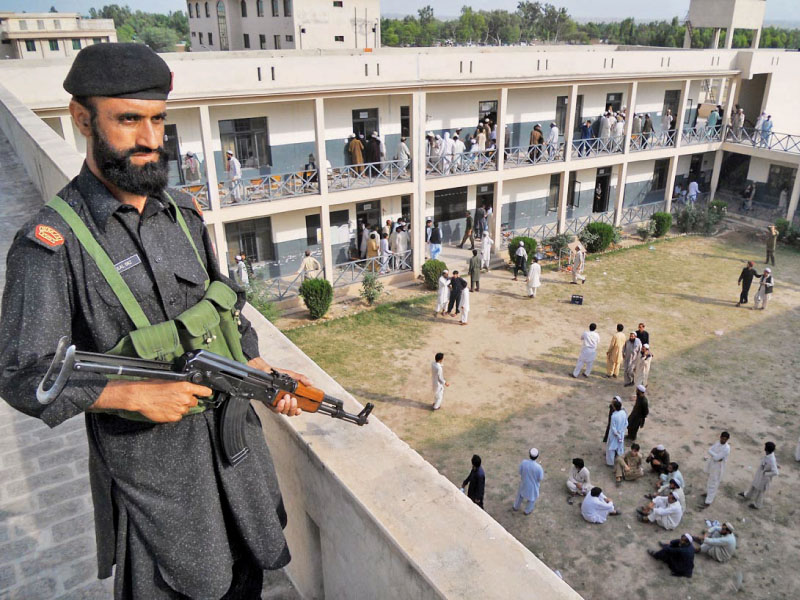 security personnel standing alert at a rooftop to avoid any untoward incident at an idp polling station photo online