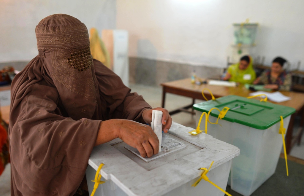 a burqa clad pakistani woman casts her vote at a polling station in peshawar on may 11 2013 photo afp