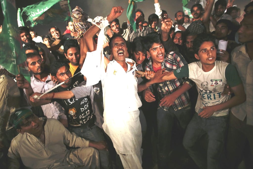 supporters cheer nawaz sharif cheer at a campaign closing rally in lahore photo afp