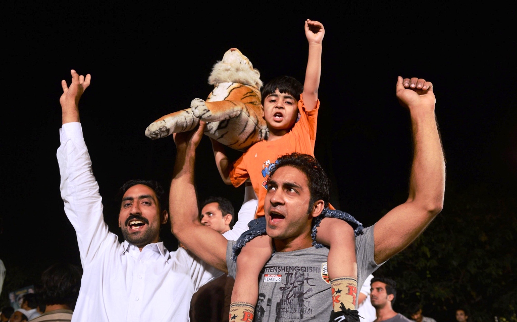 supporters of former pakistani prime minister and head of the pakistan muslim league n pml n nawaz sharif cheer as they listen to sharif outside his residence after his party victory in general election in lahore on may 11 2013 photo afp