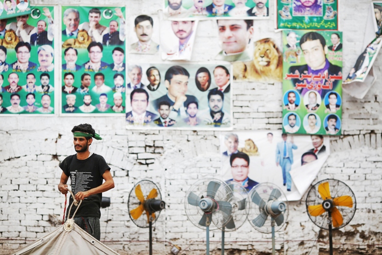 a supporter of nawaz sharif 039 s pakistan muslim league   nawaz pml n dismantles a huge tent at one of party 039 s election headquarters in lahore may 12 2013 photo reuters