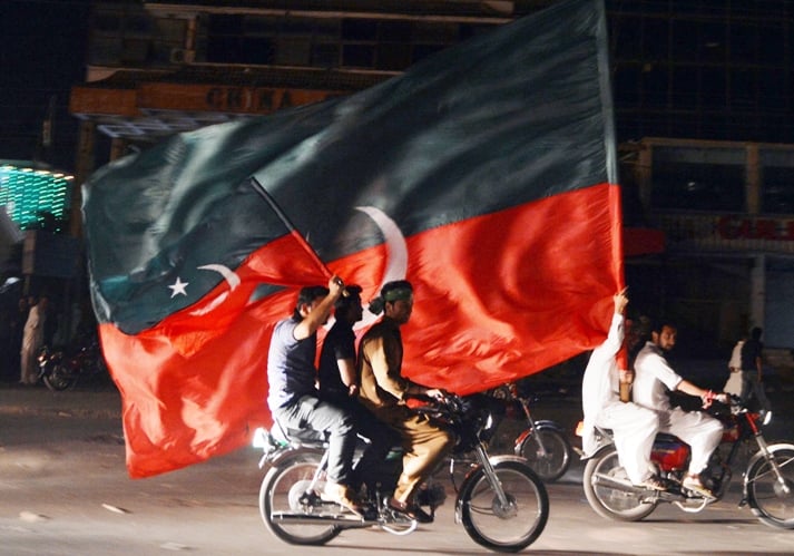 supporters of pakistani politician and former cricketer imran khan carry their party flags as they take part in a rally in rawalpindi on may 12 2013 photo afp